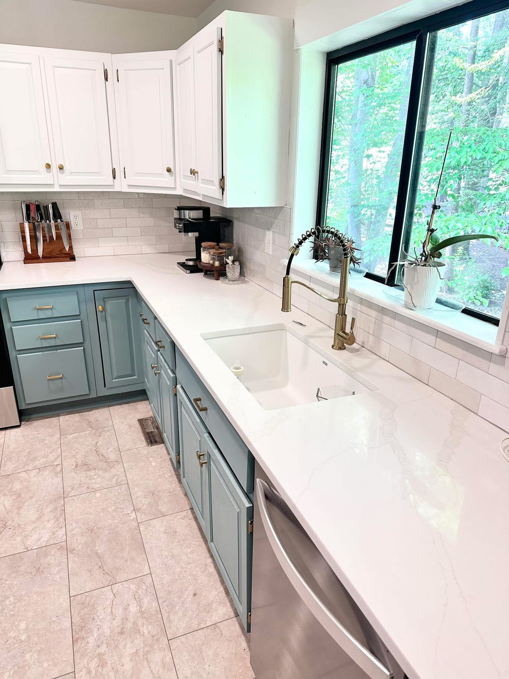 Two-tone kitchen with sage cabinetry, quartz countertops and brass fixtures
